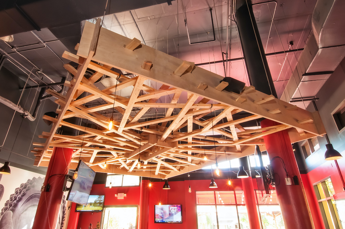 wooden structure suspended from industrial looking ceiling